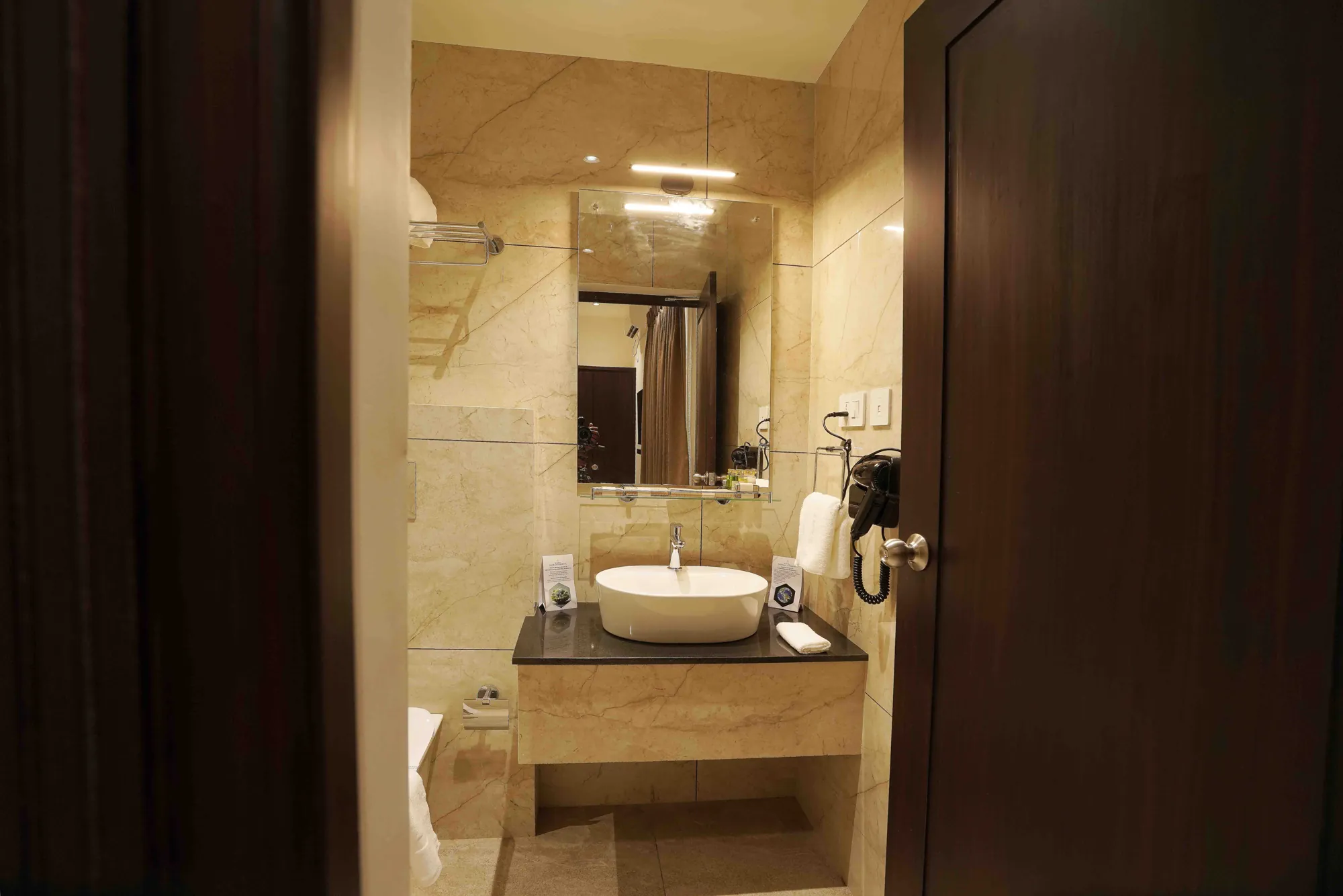 Vanity with a vessel basin, lit mirror and hair dryer