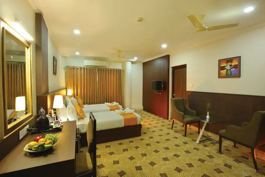 Twin room with a sitting area and fruit bowl on the desk